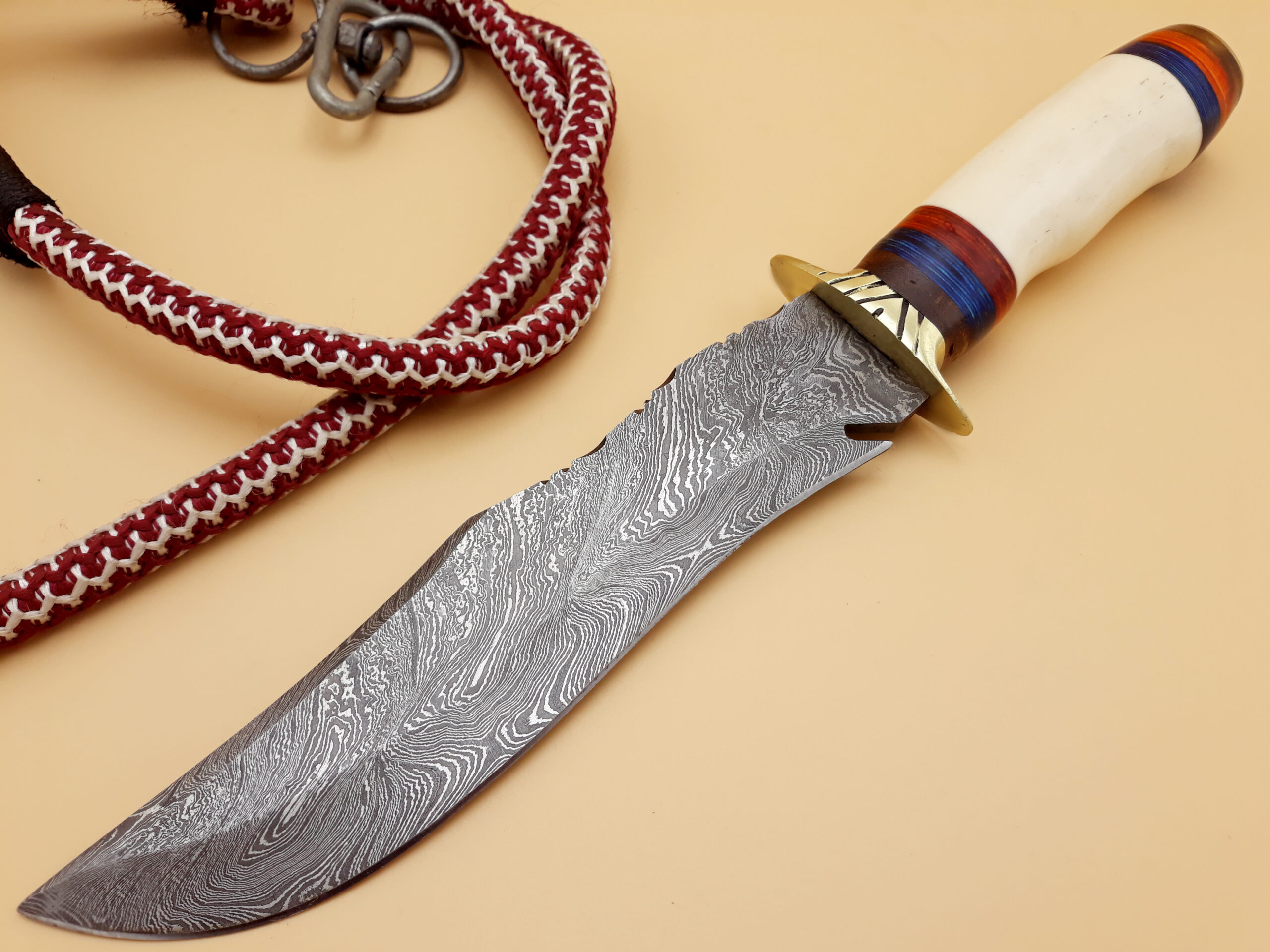 Full view of 13 inch Damascus steel survival knife with leather sheath beside it