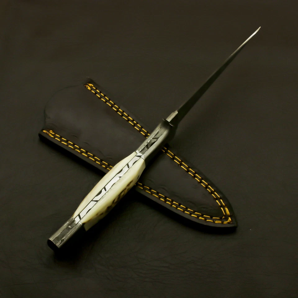 Handmade Damascus steel stag handle dagger displayed outdoors on wood log